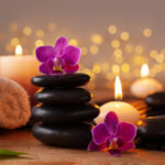 Spa, beauty treatment and wellness background with massage stone, fresh orchid flowers, towels and burning candles.
