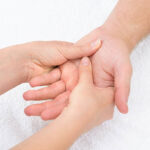 Close-up Of A Physiotherapist Massaging Palm Of A Man