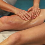 hands massaging athlete's thigh after running hands massaging athlete's thigh after running